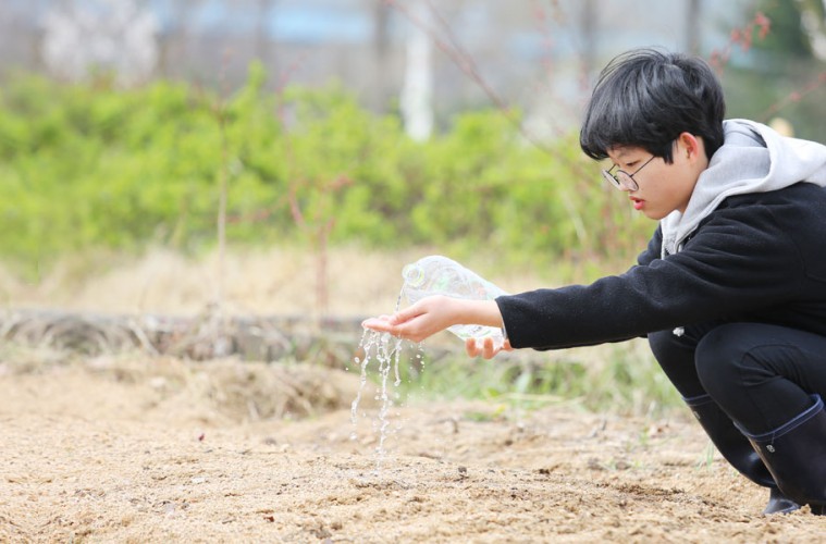 채소들이 무럭무럭 자라길 바라며 씨앗을 뿌리는 서희.