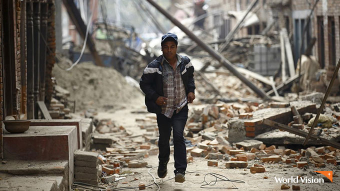 지진으로 무너진 건물들 사이로 뛰어가는 남자. 사진