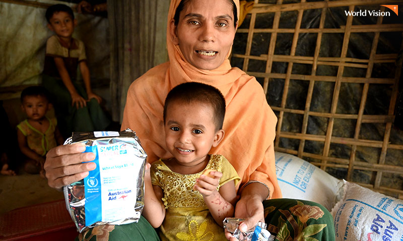 지원받은 식량을들고 있는 로힝야 난민촌의 엄마와 아이의 모습