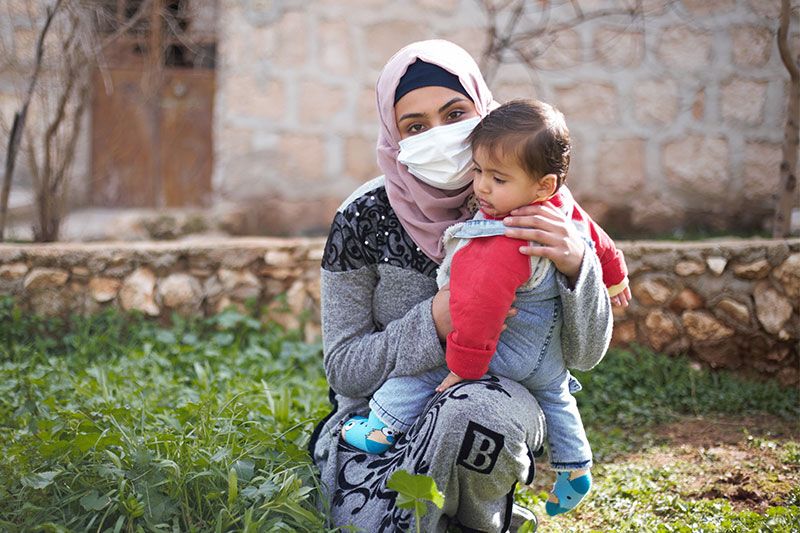 히잡을 쓰고 있는 여성이 아기를 안고 있다