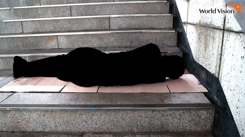 지하철 계단에서 박스를 깔고 누워있는 남자